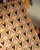 Kraftpapier Stickerbogen mit runden Herzen in schwarzem Druck und gewellter Umrandung